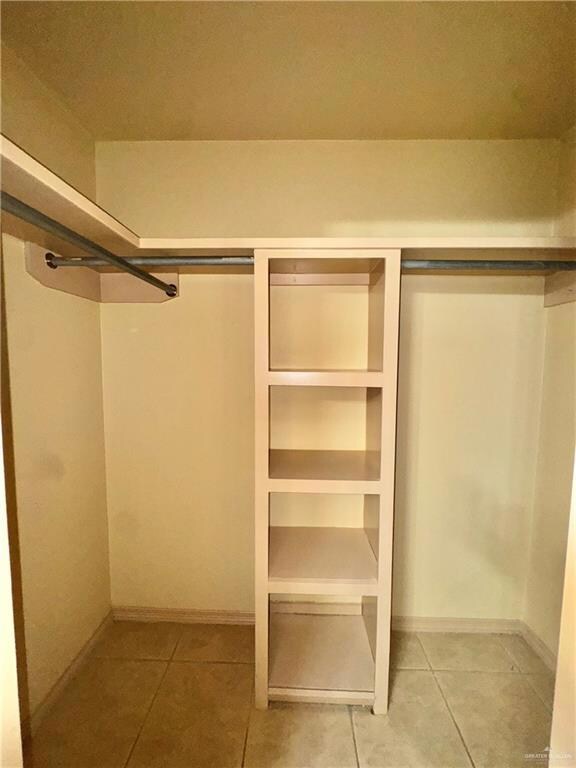 Walk in closet with light tile patterned floors