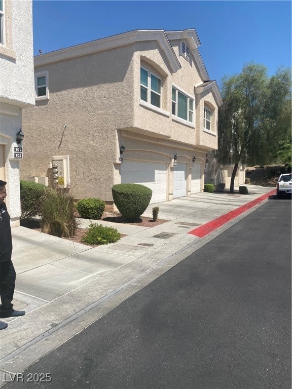 View of asphalt street featuring curbs and sidewalks