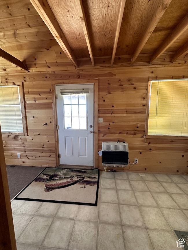 Doorway with beamed ceiling, wooden ceiling, wooden walls, and heating unit