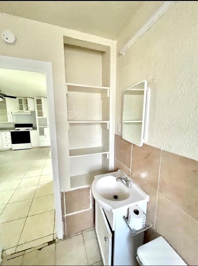 Bathroom with vanity, tile patterned flooring, toi