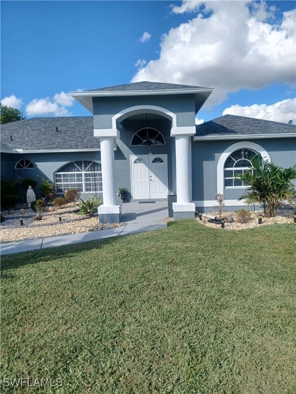 View of front of house featuring a front yard, stu
