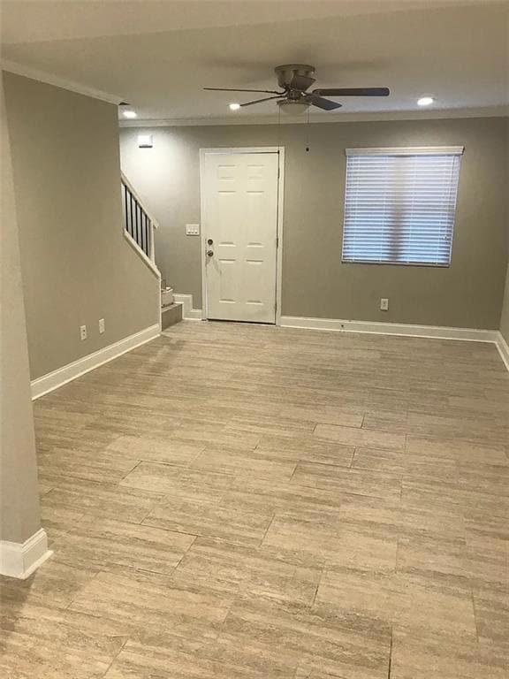 Foyer with ornamental molding, a ceiling fan, stairs, recessed lighting, and light wood-style floors