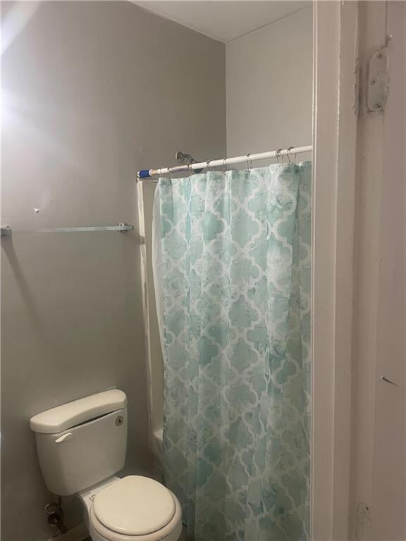 Bathroom featuring shower / tub combo and toilet