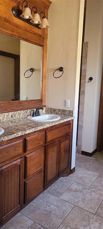Bathroom with dual bowl vanity and tile flooring