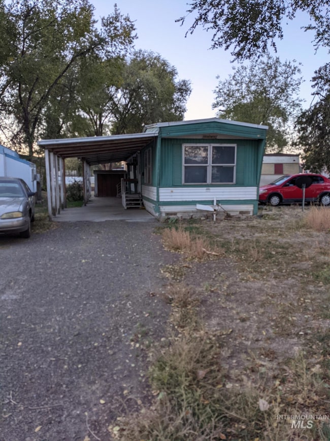View of front of house with driveway and a carport