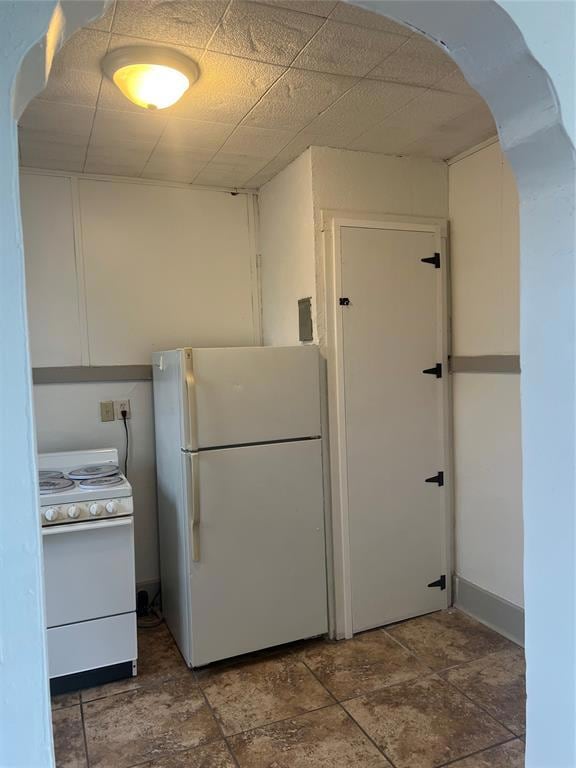 Kitchen with freestanding refrigerator, stone fini