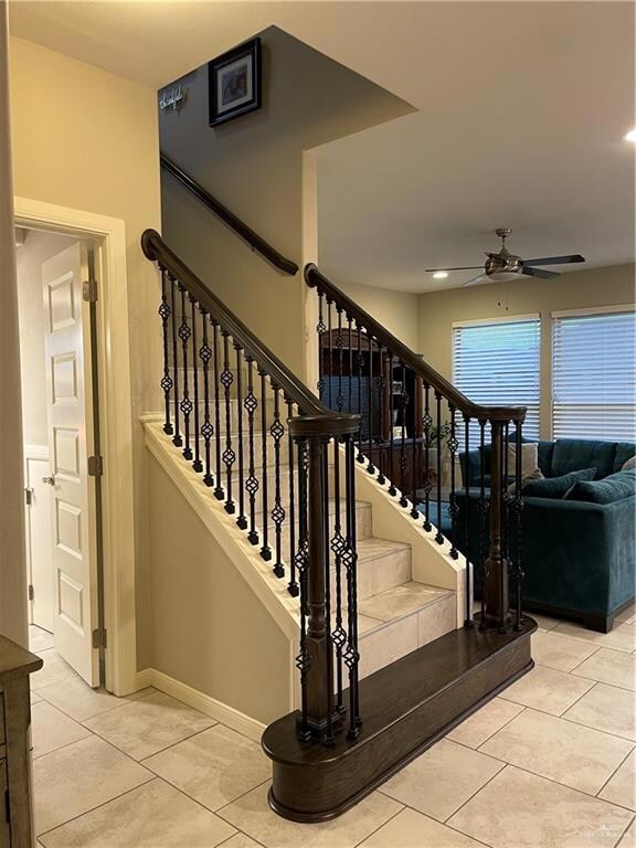 Stairs featuring light tile floors and ceiling fan