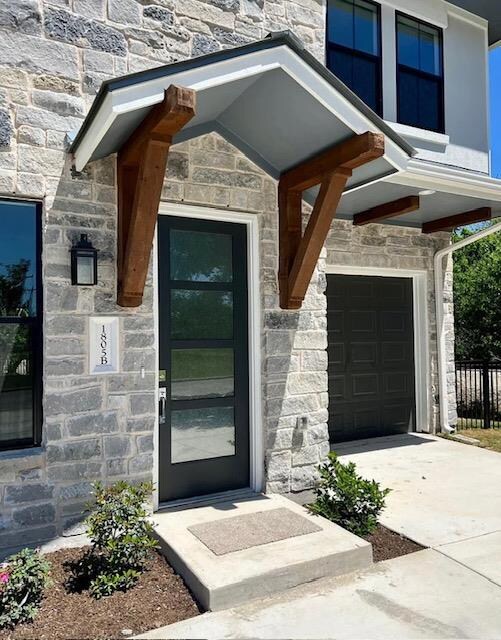 Property entrance featuring stone siding, concret
