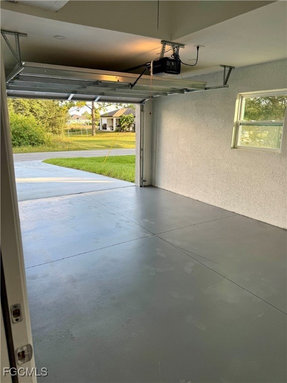 Garage featuring a textured wall and a garage door opener