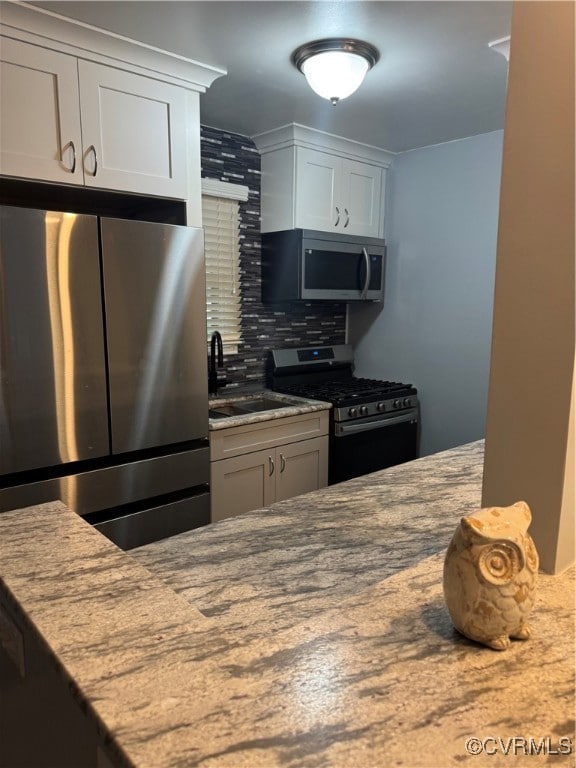 Kitchen featuring gas stove, fridge, a sink, taste