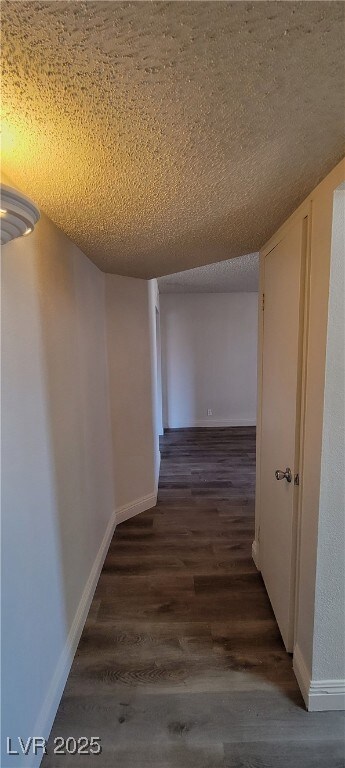 Hallway featuring dark wood-style flooring, a text
