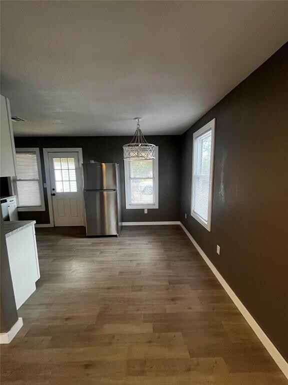 Unfurnished dining area with hardwood / wood-style