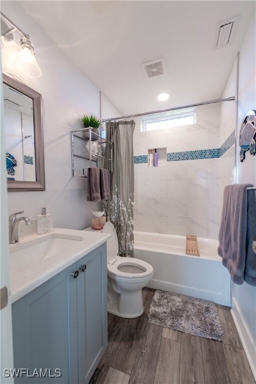 Bathroom with toilet, shower / tub combo, visible
