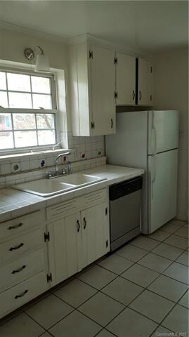 Cabinets to ceiling, tile floor in bright kitchen