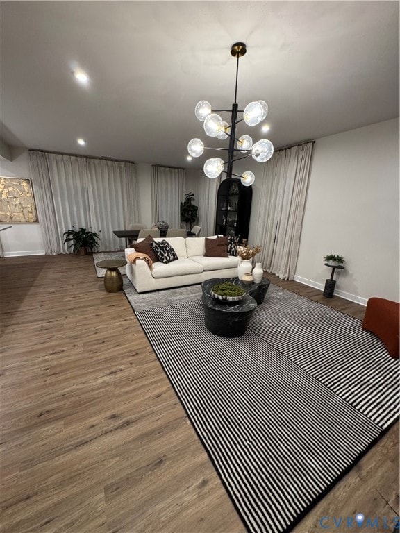 Living room featuring wood finished floors, a chandelier, and recessed lighting