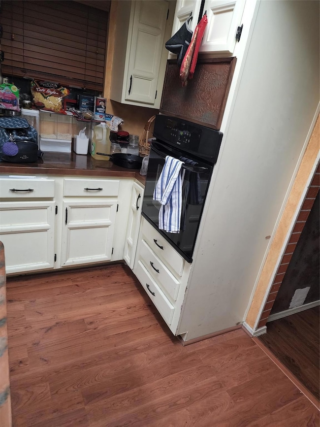Kitchen with hardwood / wood-style floors, oven, a