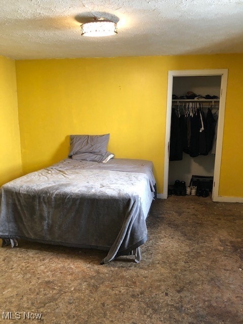 Bedroom featuring a textured ceiling, carpet floors, and a closet