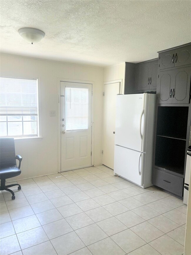 Kitchen featuring freestanding refrigerator, a te