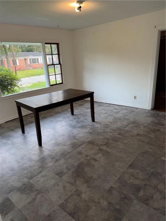 Unfurnished dining area with baseboards