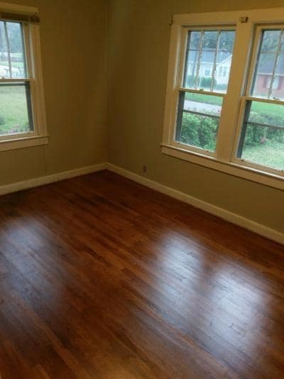 Empty room featuring dark wood-style floors and baseboards