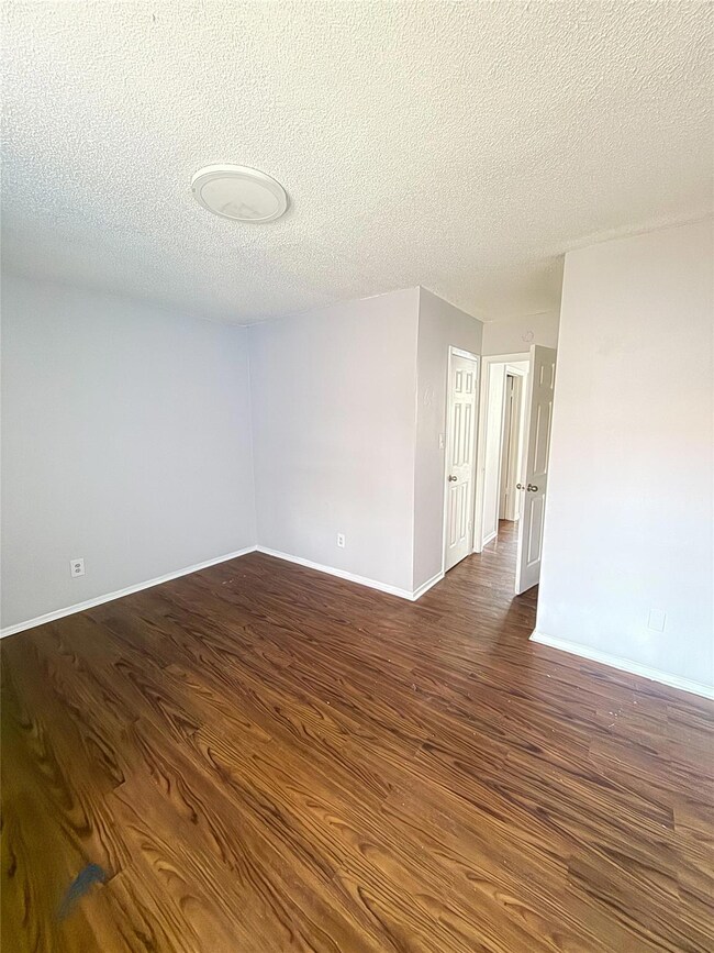 Unfurnished room featuring a textured ceiling, ba