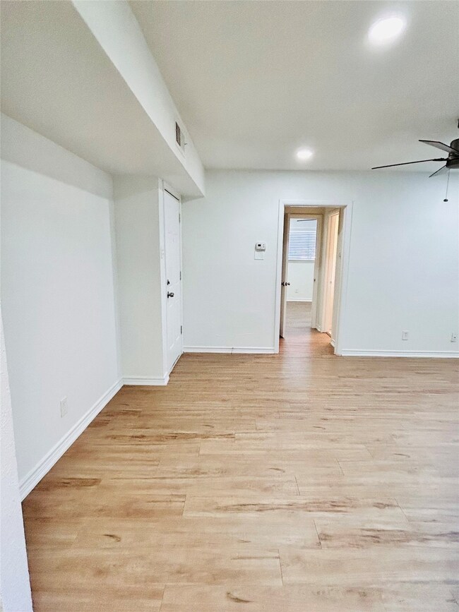 Empty room featuring ceiling fan, light wood-type flooring, and recessed lighting