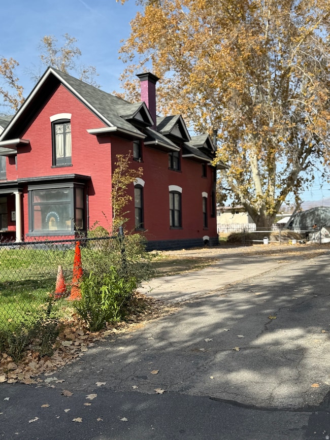 View of front of house featuring a fenced front yard, a chimney, and brick siding
