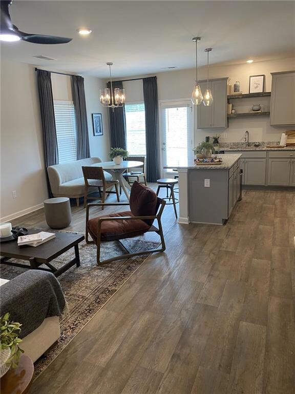 Kitchen with gray cabinets, pendant lighting, dark wood finished floors, a chandelier, and recessed lighting