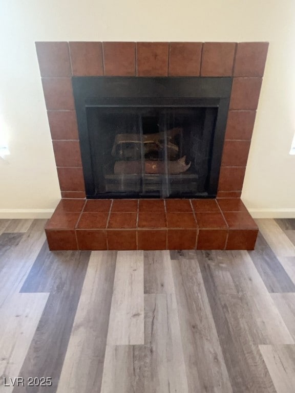 Detailed view of a tiled fireplace and wood finished floors