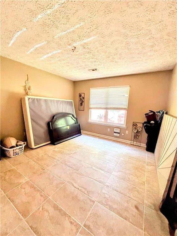 Unfurnished room with a textured ceiling and tile 
