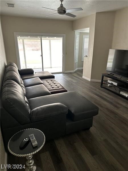Living room with ceiling fan, baseboards, wood fin