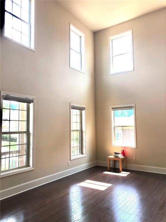 Spare room with baseboards, dark wood finished flo