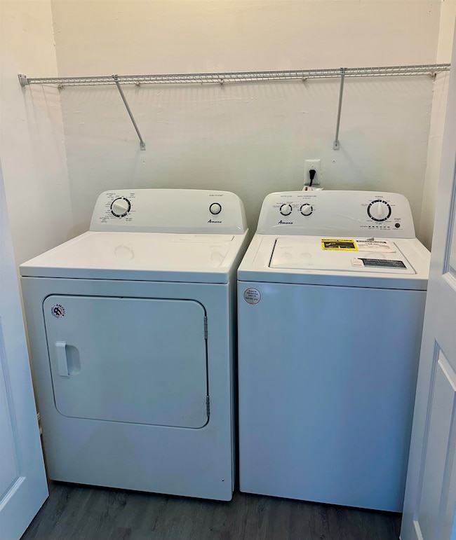 Laundry area featuring separate washer and dryer and dark wood finished floors