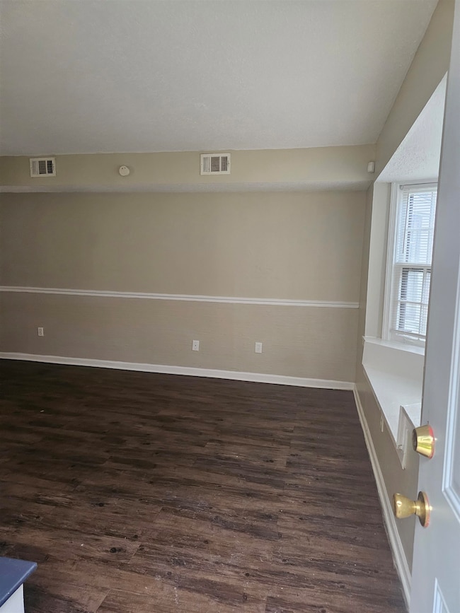 Unfurnished room with dark wood-style flooring and