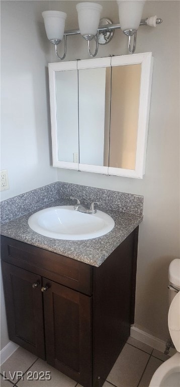 Bathroom featuring toilet, vanity, tile patterned