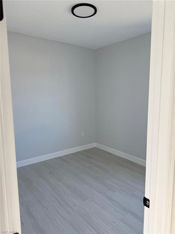 Unfurnished room featuring wood finished floors and baseboards