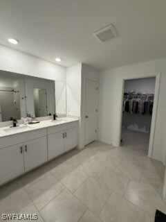 Full bath featuring a walk in closet, double vanity, and recessed lighting