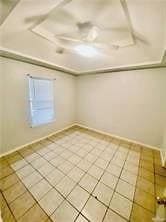 Unfurnished room with light tile patterned flooring and baseboards