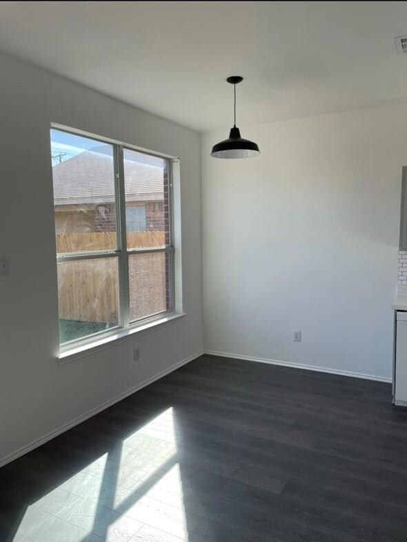 Unfurnished dining area with dark wood-type floori