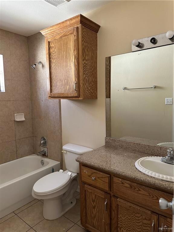 Full bath with vanity, light tile patterned floors, and shower / bath combination