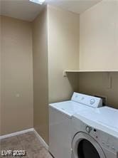 Laundry area with baseboards, washer / dryer, and