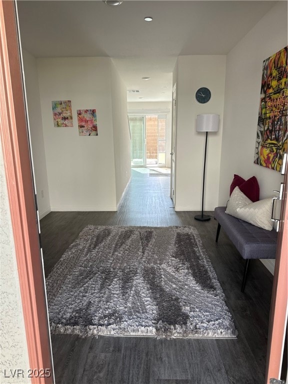 Corridor with dark wood-style flooring and baseboa