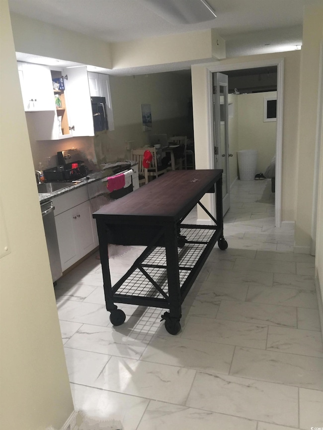 Kitchen featuring dishwasher, white cabinetry, and