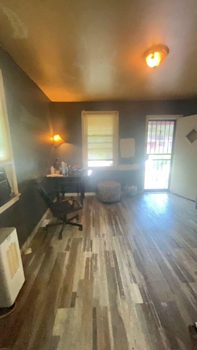 Home office featuring wood finished floors, plenty of natural light, and baseboards