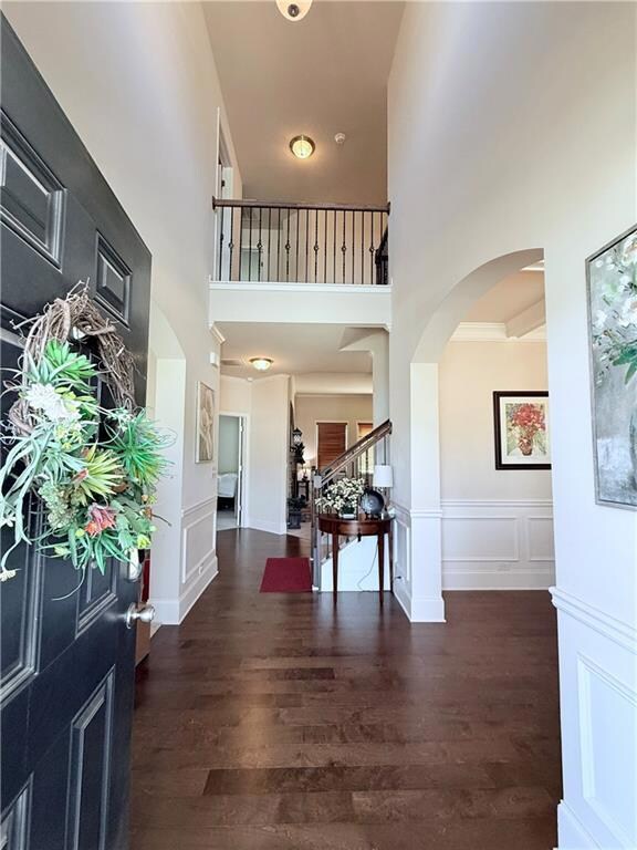 Foyer featuring stairway, a high ceiling, wood fin