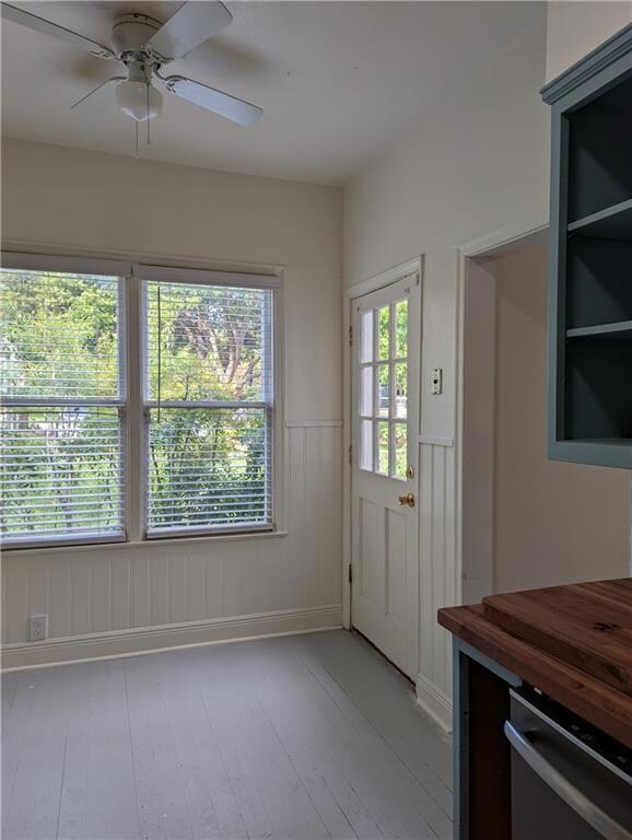 Doorway with wainscoting, light wood finished flo