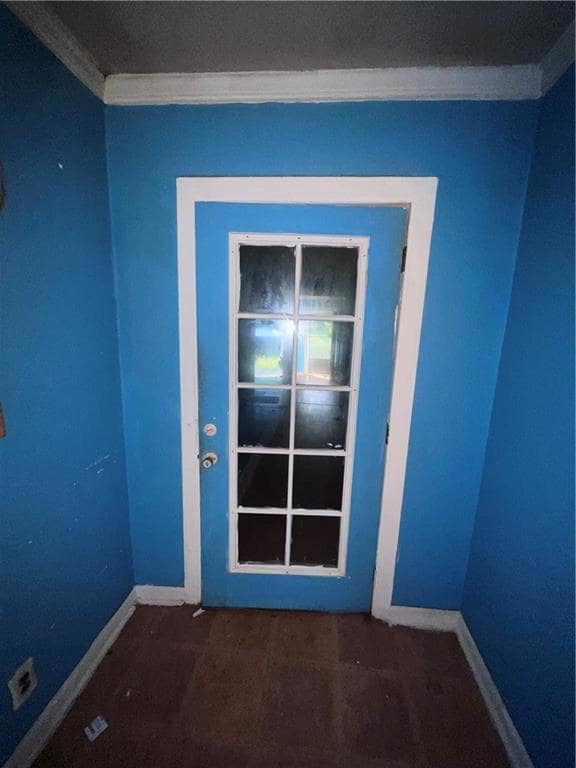 Empty room featuring ornamental molding and baseboards
