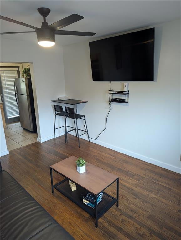 Living room featuring ceiling fan, baseboards, and