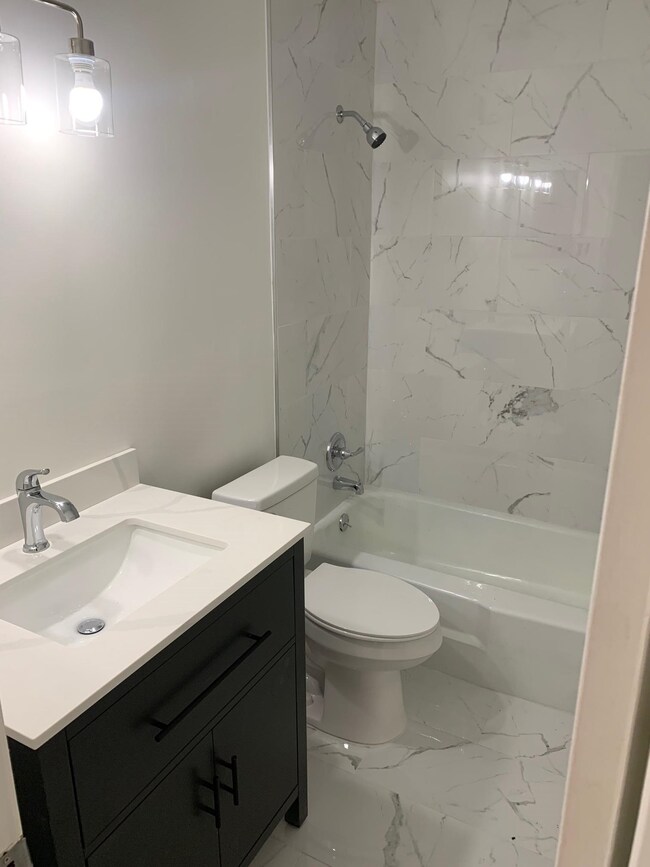 Bathroom featuring marble finish floor,  shower co