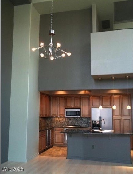Kitchen with an inviting chandelier, a high ceilin